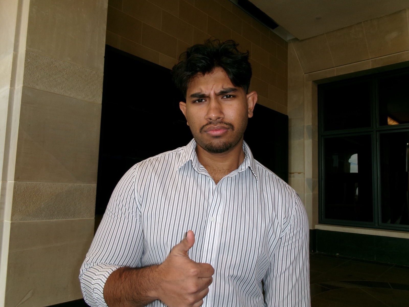 MD Rabbi in a striped shirt giving a thumbs up